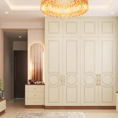 A classic and elegant floor-to-ceiling wardrobe in a soft cream finish. The paneled doors with subtle circular details and brass handles add a touch of timeless sophistication to the bedroom.