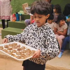 A child proudly presents a tray of "mersu," a recreation of an ancient Mesopotamian recipe found on a clay tablet. This project was a spontaneous fusion of history, geometry, and cooking.