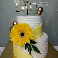 A bright and cheerful two-tiered cake for Dad, featuring a large sunflower and a "Love You Dad" topper.