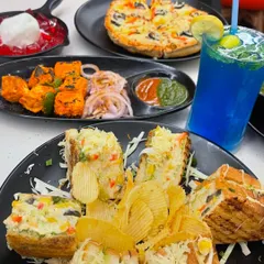 A delicious spread featuring my club sandwich, pizza, and paneer tikka. It's a perfect combination for a meal with friends.