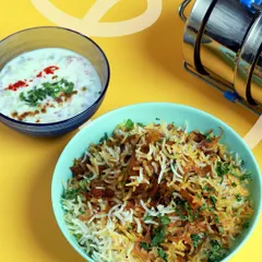 Our special Chicken Biryani served with cooling raita. It's a weekend favorite and a party classic, slow-cooked with fragrant spices to capture that authentic home-style flavor.
