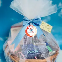 A classic wicker basket hamper designed for him, beautifully wrapped in white and blue tulle with a satin bow. These baskets can be customized with a variety of products, from grooming essentials to gourmet snacks.