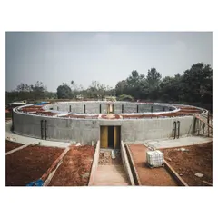 The circular concrete form of the sunken gallery under construction. This photo shows the scale of the structure and the beginning of its integration into the earth.
