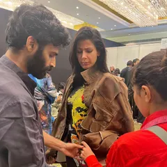 Another backstage moment, ensuring the fit and fall of a jacket is perfect just before the model walks the ramp for Huemn.
