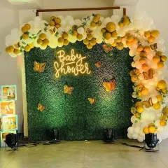 Here, a custom 'Baby Shower' neon sign is mounted on an artificial green hedge wall. This combination is perfect for bringing an element of the outdoors inside and creating a fresh, vibrant atmosphere.