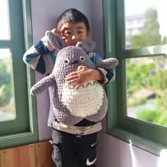 Seeing the joy my creations bring is the best reward. Here is a happy customer with a large, cuddly Totoro plushie I made, perfect for fans of Studio Ghibli.