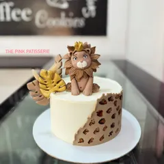 A modern and stylish lion cake. The design features a handcrafted fondant lion king and a leopard print pattern on the side for a chic jungle theme.