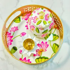 This Pichwai-style set, featuring a tray, a jar, and a brass lotus diya, is perfect for festive gifting and decor. The design is inspired by traditional Indian art, adding an elegant touch to any celebration.