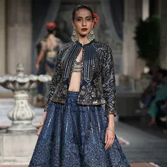 A high-fashion runway look featuring a blue lehenga with a structured, embroidered jacket. This shows the kind of unique, trend-setting pieces you can find in my collection.
