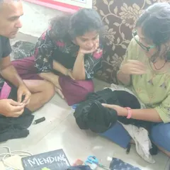 Our textile mending sessions are relaxed and collaborative. Here, participants are gathered on the floor, sharing tips and learning hand-sewing techniques together. It’s a perfect example of our grassroots, community-first approach to repair.