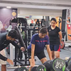 Strength and conditioning are non-negotiable. Here, I am supervising a player's form during a weightlifting session to build explosive strength for smashes and jumps.