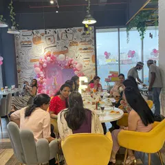 A view of our cafe during a party, where parents can sit back, chat, and enjoy a meal. The large windows and comfortable seating make it a bright and pleasant space for adults to relax.