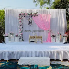 A simple yet beautiful engagement setup. We used a clean white backdrop with a pop of pink drapery, a custom monogram for the couple, and a delicate floral arch to create a light and romantic atmosphere.