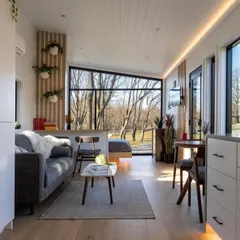 Step inside one of our modular holiday homes. This bright and airy living space, with its large windows and minimalist decor, shows that compact living doesn't mean compromising on style or comfort.