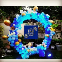 I also create decorations for outdoor events. This circular balloon arch, made with blue, white, and gold balloons, serves as a beautiful photo backdrop for birthdays or baby showers. I added small lights to make it stand out in the evening.