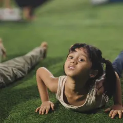 A young CaliKid learning the cobra pose, an important exercise for building back strength and flexibility.