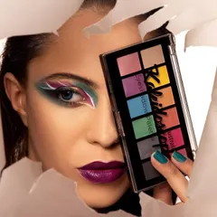A striking beauty shot where a model with dramatic eye makeup peers through a tear in white paper, holding up an eyeshadow palette. This is a highly commercial and creative concept for a cosmetics brand.