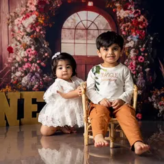Big brother sits proudly next to his baby sister as she celebrates her first birthday. Our sessions are designed to make kids feel comfortable, allowing us to capture their unique personalities and relationships.