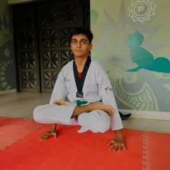 A student demonstrates a challenging yoga pose, showcasing the blend of strength, balance, and flexibility we cultivate in our classes.