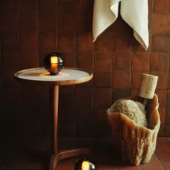 The Bocci 14p portable lamps in a bathroom setting. Their warm, rippling glow creates a serene, spa-like atmosphere. They are available in Clear, Grey, and Sepia glass.