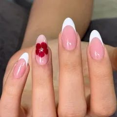 A closer look at the elegant white French manicure with a single, detailed 3D red flower accent nail.