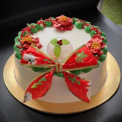 A simple and beautiful Christmas cake with a festive bow and poinsettia decorations. Merry Christmas to all!