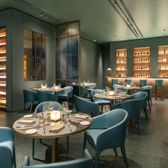 A wider perspective of the Armani Caffe dining room, showcasing the impressive wine storage unit. This shot is designed to communicate the breadth of the restaurant's offerings and the thoughtful layout of the space, from the bar to the seating arrangements.