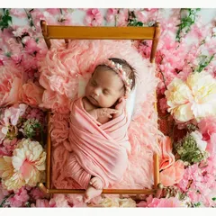 Nestled in a bed of soft pink flowers, this newborn is the picture of serenity. We love using floral elements to add a touch of natural beauty and color to our newborn photography sessions.