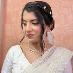 For this bride's church wedding, I created a beautiful braided updo, adorned with small, delicate white flowers. It's an elegant style that perfectly complements her white saree and veil.