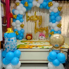 A classic 'Welcome Baby Boy' decoration for a home. We created a balloon arch around a seating area with foil balloons and props like a teddy bear.