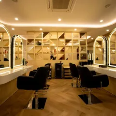 The styling stations are the heart of the salon. Here, we focused on creating a sense of personal luxury with individual backlit mirrors, comfortable hydraulic chairs, and a striking geometric feature wall that adds texture and depth.