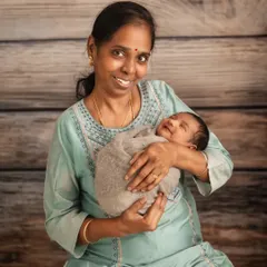 The joy of a grandmother holding her new grandchild. The baby's sweet smile makes this a truly precious moment, showing how we can include the entire family in newborn sessions.