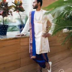 A handsome groom in a traditional dhoti and kurta, looking sharp and ready for his wedding ceremony.