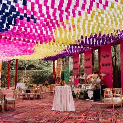The ceiling of this Mexican fiesta is a riot of color, with woven fabric strips creating a dynamic overhead installation. The entire space is designed to be an immersive experience of joy and passion.