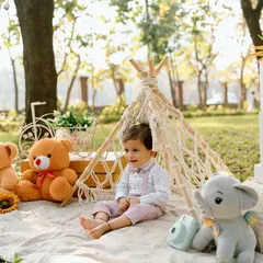 Another angle of our little picnicker, capturing his sweet expression as he enjoys the fresh air and his teddy bear companions.