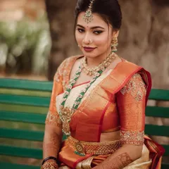 This bride is radiant in a traditional off-white and orange Kanjivaram saree. I designed the blouse with delicate floral embroidery on the sleeves to complement the richness of the silk.