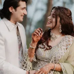 A candid shot of a happy couple, with the bride's beautiful mehndi on display. Her smile says it all.