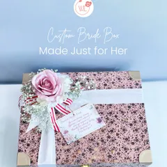 A custom bride box, made just for her. This beautiful floral-printed suitcase is adorned with a personalized note and a silk flower arrangement.