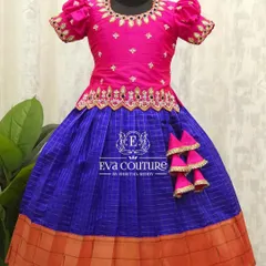This bright pink and blue checked Kanchi Pattu lehenga is a classic. The blouse is adorned with mirror work and embroidery, and the outfit is finished with cute latkans.