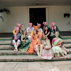 A beautiful family portrait blending cultures, with guests from Germany dressed in colorful Indian attire for the wedding.