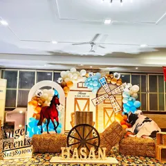 A rustic cowboy theme featuring a barn backdrop, hay bales, and farm animal cutouts.