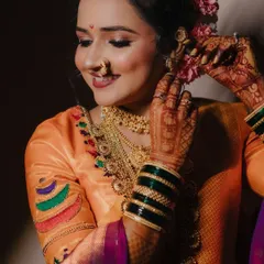 A candid moment of the bride adjusting her floral hair accessory, her smile radiating pure happiness and excitement.