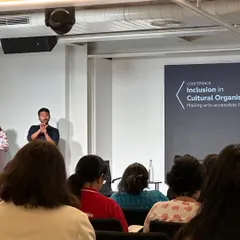 A sign language interpreter at the conference on making arts accessible. This visual is a powerful reminder that inclusive design must consider a wide spectrum of human experience and ability.