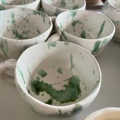 A close-up of the hand-pinched mugs with green splash glaze. The cafe wanted an organic look, and I love how imperfectly perfect they turned out.