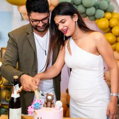 The cake cutting is a central part of any celebration. Here, the happy couple cuts their gender reveal cake at their baby shower, surrounded by modern, elegant decorations.