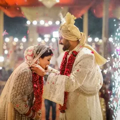 The groom places the varmala around the bride's neck, a key moment filled with smiles and the sparkle of pyrotechnics.