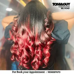 A fiery red ombre that makes a powerful statement. We achieved this vibrant look by carefully blending a deep root into bright, curled ends, ensuring the hair remains healthy and full of life.