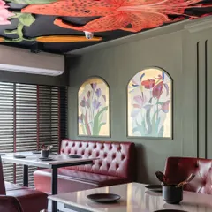 I believe ceilings are canvases waiting for a story. For this restaurant, I created a modern fresco of vibrant, oversized lilies and botanicals, turning the space above into a lush, dramatic garden that diners can get lost in.