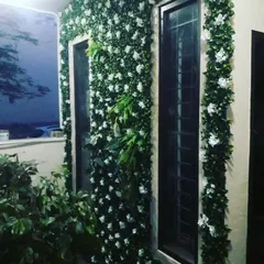Here, I used artificial ivy with small white flowers to frame the windows of a house. This adds a classic, charming look to the exterior and is a great option for home event decoration or permanent installation.