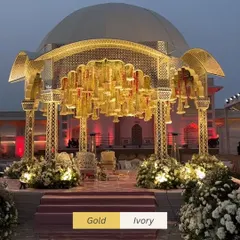 The elegance of gold and ivory comes together in this regal mandap design. The intricate lattice work and hanging floral chandeliers create a space that is both traditional and timelessly luxurious.